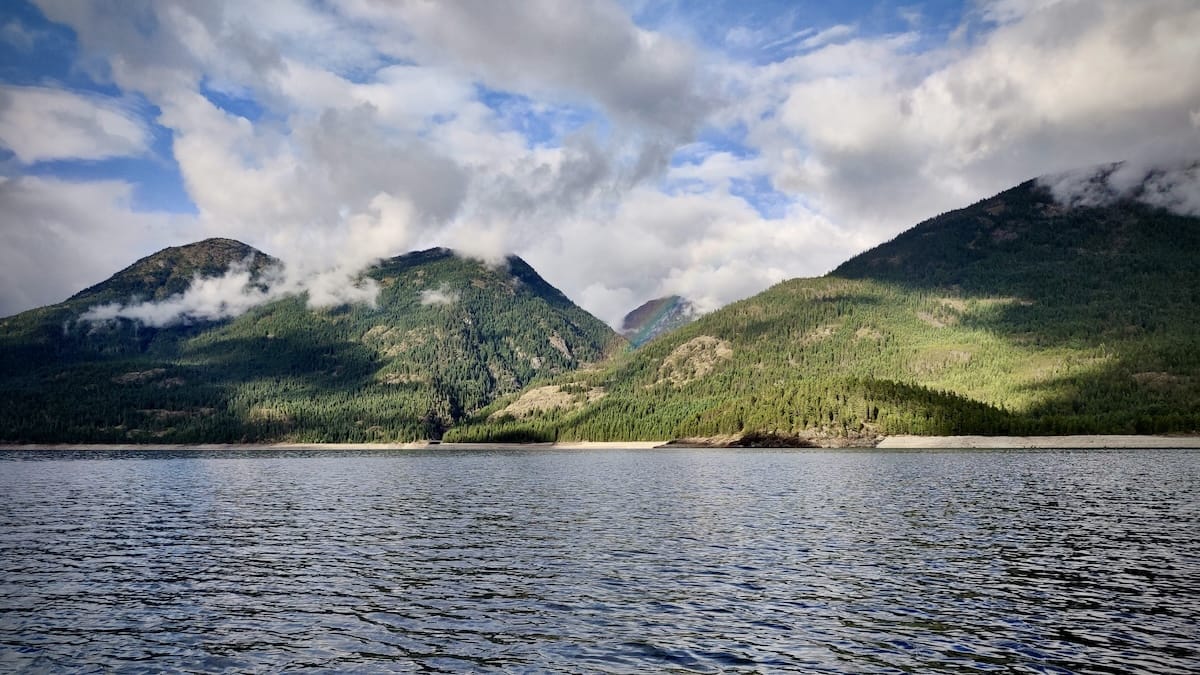 Lake in front of green mountains on a sunny day